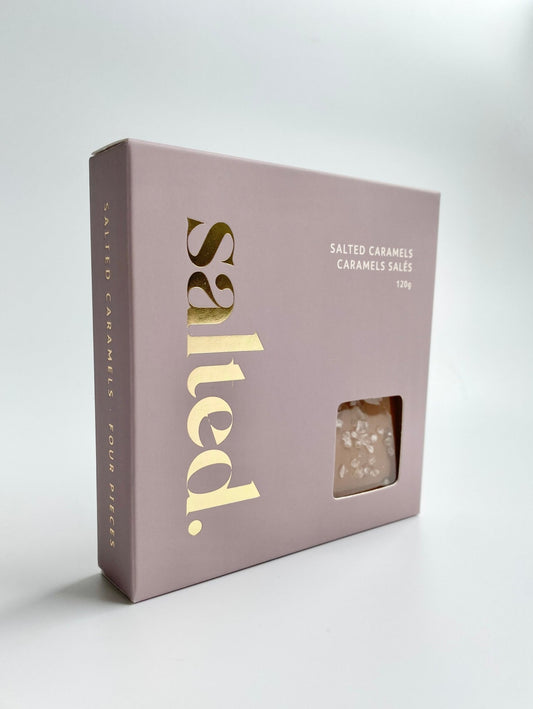 Four classic sea salt caramels in elegant gift box showing golden brown handmade treats
